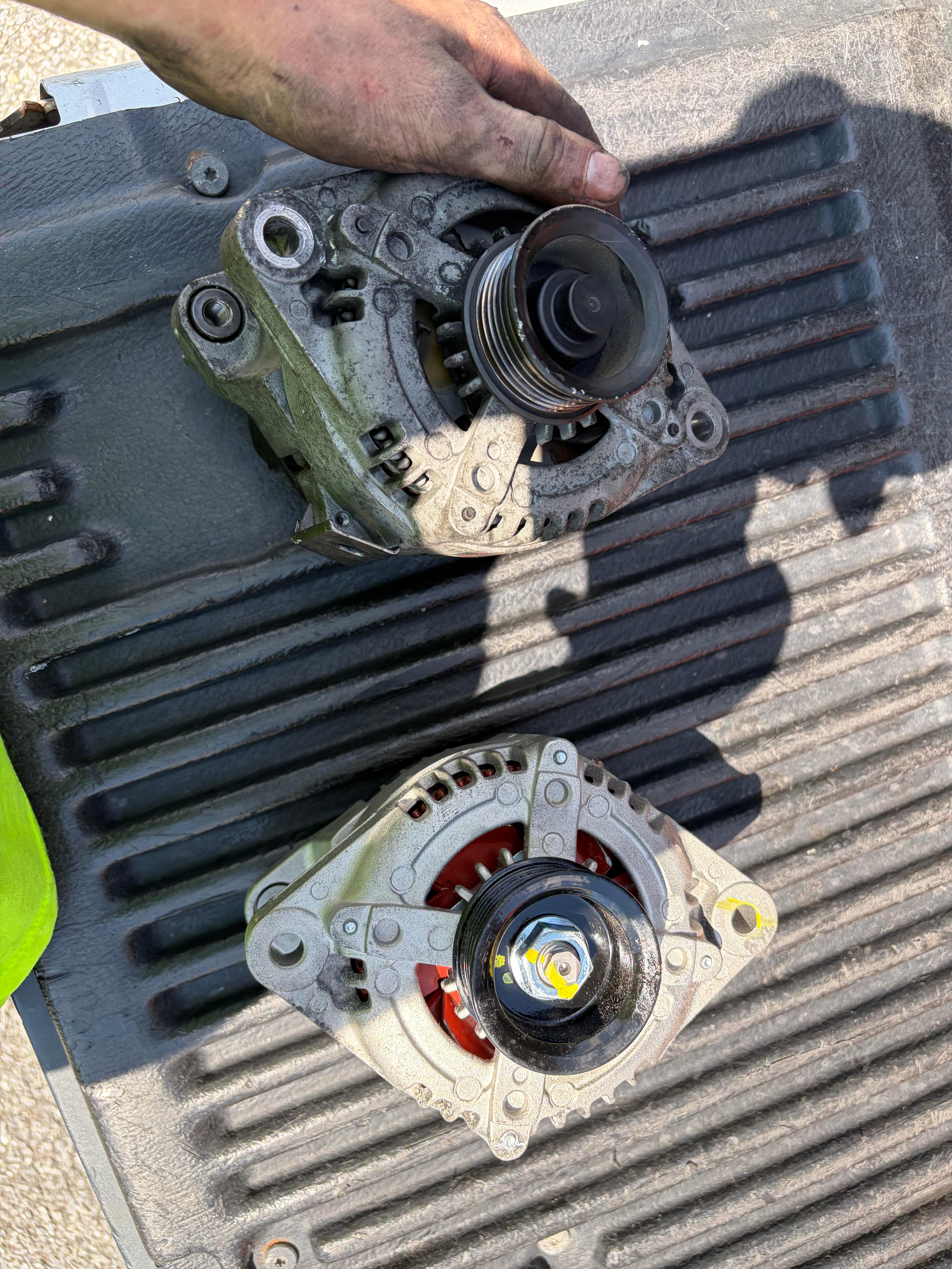 A closer look at the old alternator alongside the new one.